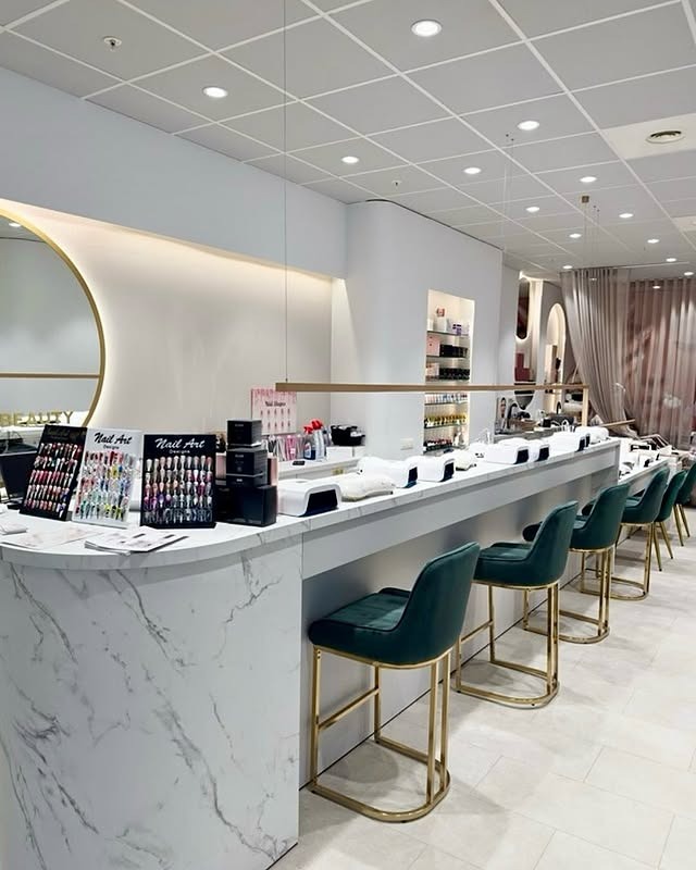 Interieur Nail & Beauty Studio — marble balie, gouden accenten, groene stoelen