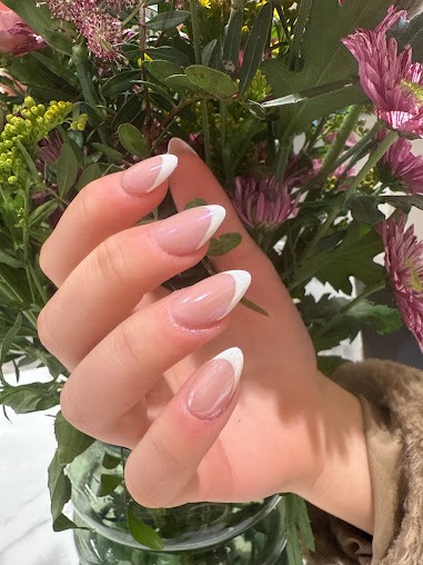 Delicate French manicure gehouden voor bloemen — lifestyle shot